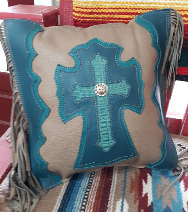 green and beige leather pillow with a cross